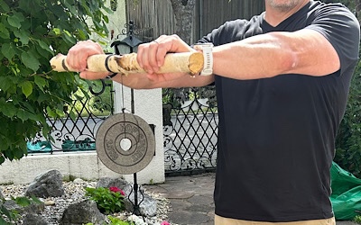 Thick-handled wrist roller made from a cut branch, string and a spare weight plate
